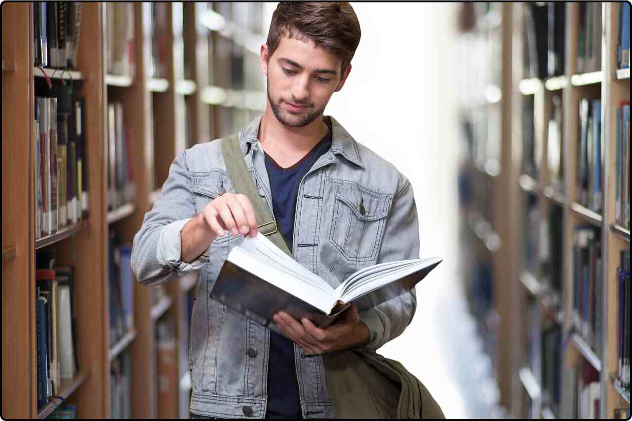 Library scene with a man deeply focused on reading a book